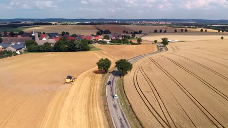 Luftaufnahme-Eines-Autos-Und-Eines-Mähdreschers-Durch-Felder-In-Deutschland