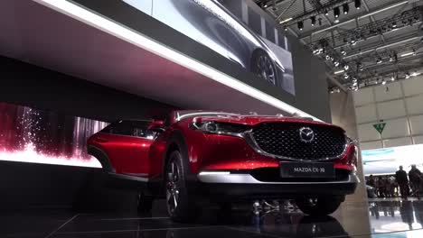 Geneva,-Switzerland---March-12th,-2019:-Wide-low-angle-shot-of-a-red-Mazda-CX-30-at-Autosalon-Geneva-Motor-Show-2019,-Switzerland