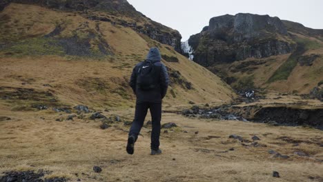 Lost-tourist-wander-near-Icelandic-mountain-landscape-and-rocky-river-bed