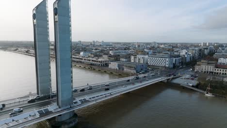 Jacques-Chaban-Delmas-bridge-and-CAP-Sciences-children's-museum-in-the-Garonne-River-shore,-Aerial-close-in-shot