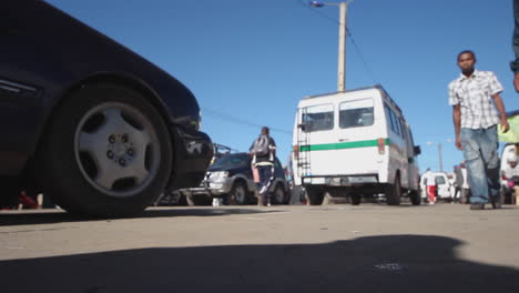 Vista-De-ángulo-Bajo-De-Personas-Y-Automóviles-Que-Pasan-Por-La-Calle-En-Antananarivo