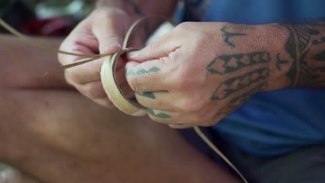 Hawaiian-men-exercising-the-tradition-of-weaving-with-hala-tree-leafs---High-angle-Close-up-shot