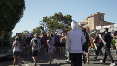 Young-hooded-male-rides-skateboard-during-George-Floyd-protest