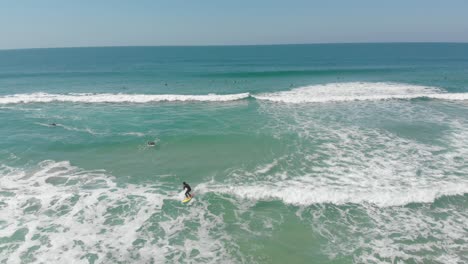 Vida-Costera,-Surfista-Aprendiendo-A-Navegar-Sobre-Las-Suaves-Olas-Espumosas-De-La-Playa-De-Santinho-Ciudad-De-Florianópolis-Brasil