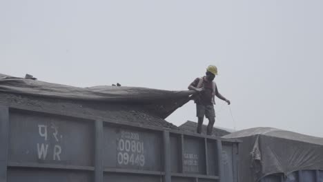 Trabajador-Cubriendo-Carbón-Cargado-En-Vagón-De-Carga