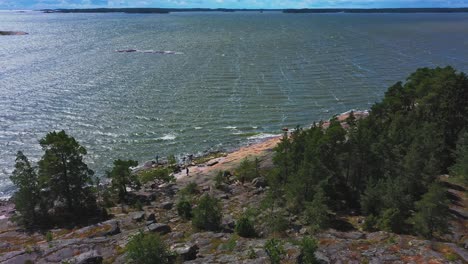 Gente-Paseando-Perros-En-La-Isla-Del-Archipiélago-Finlandés-En-Un-Día-Ventoso,-Toma-Aérea