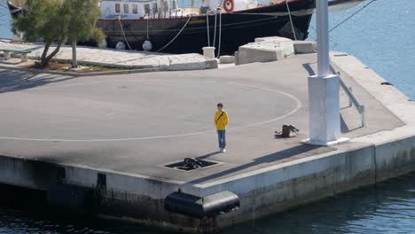 Junge-Mit-Gelbem-Kapuzenpulli-Steht-Am-Hafen-Und-Wartet