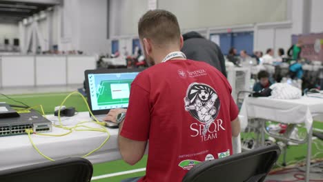 Adult-Male-Engineer-Working-On-Laptop-At-Robocup-Tournament-In-Montreal