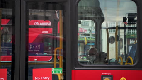 Transporte-Público-En-Londres-Durante-El-Cierre-Del-Coronavirus-Covid-19-Con-Un-Hombre-En-Un-Autobús-Rojo-De-Londres-Con-Mascarilla-Cuando-El-Transporte-Público-Estaba-Tranquilo-Y-Desierto-Sin-Gente-En-Inglaterra,-Europa