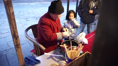 Ein-Süßwarenhersteller-Stellt-Auf-Dem-Markt-Der-Wasserstadt-Gubei-Für-Ein-Schwangeres-Mädchen-Eine-Ratte-Aus-Süßigkeiten-Her