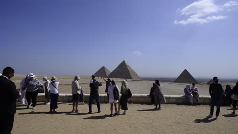 Tourists-taking-pictures-with-the-Giza-Pyramids-in-the-background,-Egypt