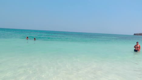 Tourists-are-enjoying-and-swimming-in-a-turquoise,-clear-and-transparent-beach-of-a-paradisiac-island-near-Cartagena-de-Indias,-Colombia