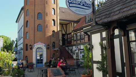 People-eating-at-the-Tower-pizza-restaurant,-sunny-day,-in-Solvang,-California,-USA---Static-shot