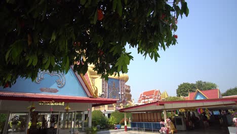 Große-Goldene-Buddha-Statue-Im-Farbenfrohen-Park-In-Thailand,-Filmische,-Aufschlussreiche-Aufnahme-Mit-Klarem-Himmel