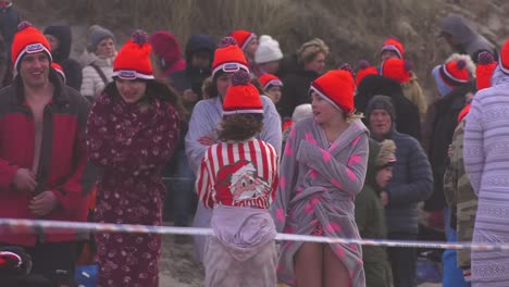 Grupo-De-Niños-Temblorosos-Esperando-En-Fila-En-La-Playa-De-Texel,-Listos-Para-Bucear-En-La-Zambullida-De-Año-Nuevo,-En-El-Norte-De-Holanda,-Países-Bajos---Toma-Estática-Media