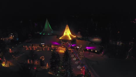 Vista-Aérea-Alrededor-Del-Pueblo-De-Papá-Noel,-Durante-La-Noche,-En-Rovaniemi,-Finlandia---órbita,-Disparo-De-Drone