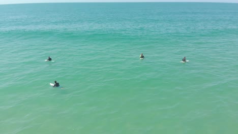 Vista-Aérea-De-Surfistas-Esperando-Pacientemente-La-Próxima-Ola-En-Praia-Do-Santinho,-Brasil---4k,-24-Fps