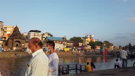 Escena-Diurna-En-El-Barrio-De-Ramkund-En-Nashik,-India,-Con-Devotos-Bañándose-En-El-Río-Godavari-Y-El-Templo-Shree-Ganga-Godavari-En-Las-Orillas