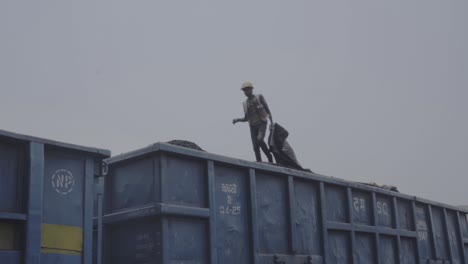 Trabajador-De-La-Industria-Del-Carbón-Caminando-Sobre-Mineral-De-Hierro-Cargado-En-Un-Vagón-De-Reparto