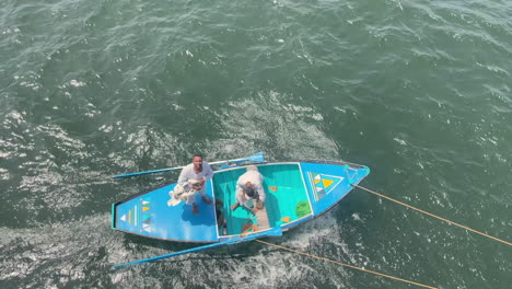 Two-africans-on-a-blue-boat-yelling-at-the-crew-of-a-cruise-ship-on-nile-river