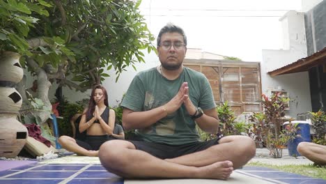 Pullback-Shot-Towards-Yoga-Coach-Meditating-In-Nature-With-Her-Students,-Lima,-Peru