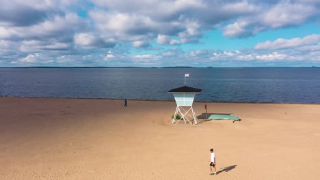 Vista-Aérea-De-La-Casa-De-Salvavidas,-En-La-Playa-De-Nallikari,-En-Oulu,-Finlandia---Seguimiento,-Disparo-De-Drone