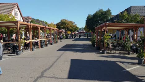 Gente-Comiendo-Y-Caminando-Por-La-Calle-En-Solvang,-California-En-Un-Día-Soleado---Toma-Estática-Portátil