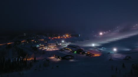 Vista-Aérea-Alrededor-De-La-Estación-De-Esquí-De-Yllasjarvi,-Niebla,-Tarde-De-Invierno,-En-Yllas,-Laponia---órbita,-Disparo-Con-Drones