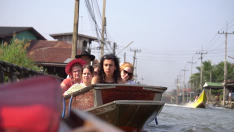 Cinematic-Slow-Motion-View-of-Tourists-on-Boat-Sailing-on-Floating-Market-Tour,-Thailand