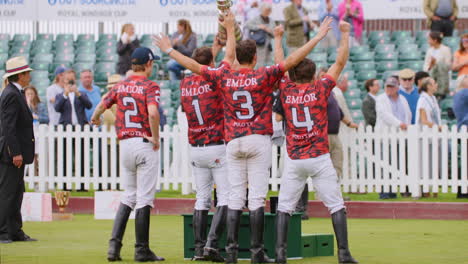 Emocionado-Equipo-De-Polo-Levanta-El-Trofeo-En-Celebración-De-La-Victoria.