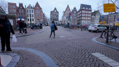 Quiet-Amsterdam-street-corner-with-bicycles,-historic-architecture,-and-cobblestone