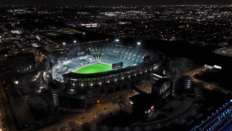 Disparo-De-Un-Dron-Dando-Vueltas-En-El-Estadio-De-Campo-De-Tarifa-Garantizada-Iluminado-Por-La-Noche,-Invierno-En-Chicago