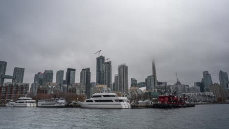 Timelapse-De-Una-Vista-Nublada-Del-Horizonte-De-Toronto-Con-Barcos-Atracados-A-Lo-Largo-Del-Paseo-Marítimo,-Torre-CN-Oscurecida-Por-La-Niebla