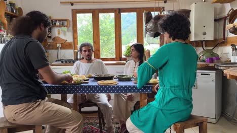 hopeful-couple-sitting-around-dining-table-in-rural-life-in-Iran-countryside-the-local-people-gathering-to-serve-meal-food-cooking-time-persian-cuisine-delicious-toast-wine-in-wood-hut-talking-party