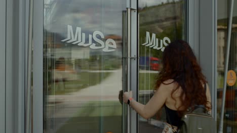 Rear-view-of-female-tourist-with-backpack-entering-Museum-of-the-Sciences