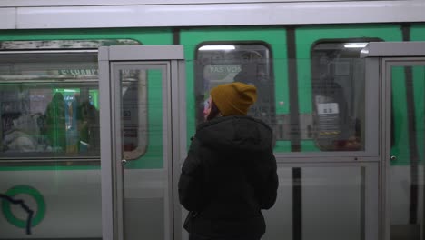 Female-passanger-waiting-for-the-Metro-while-the-other-railroad-the-green-metro-leaves-the-platform