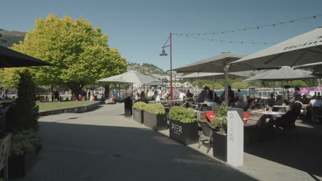 Gente-Cenando-En-Un-Restaurante-Al-Aire-Libre-Junto-Al-Puerto-Deportivo-De-Queenstown,-Nueva-Zelanda