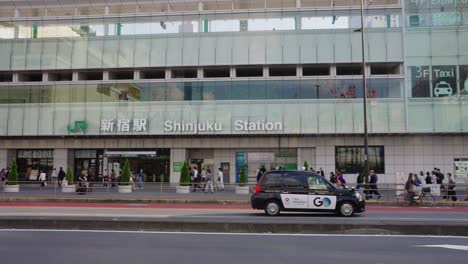 Menschen,-Die-Auf-Den-Straßen-Von-Shinjuku-Laufen,-Während-Das-Taxi-Vor-Dem-Hauptbahnhof-Im-Stadtgebiet-Von-Shinjuku-Ankommt