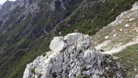 Vista-Aérea-Panorámica-De-Un-Hombre-De-Pie-En-La-Cima-De-Una-Colina-En-El-Embalse-De-Bovilla-Con-Vistas-Al-Lago-Bovilla,-Albania,-Europa