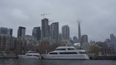 Yates-Amarrados-En-El-Puerto-De-Toronto-Con-La-Torre-CN-Envuelta-En-Niebla-Y-Como-Telón-De-Fondo-De-La-Ciudad