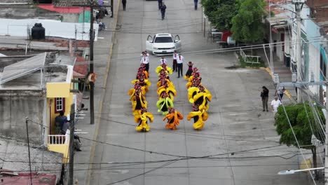 Aerial-view-showing-woman-in-costume-dancing-on-street-at-Mariachi-Festival-in-Tecalitlan,-Mexico