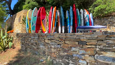 Colorida-Colección-De-Tablas-De-Charcos-En-Una-Villa-Tropical-Junto-A-La-Playa-En-El-Sur-De-Francia-Con-árboles-Verdes-Y-Cielo-Azul,-Divertidas-Vacaciones-Soleadas,-Actividades-Deportivas,-Tomas-De-4k