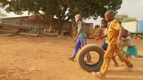 Un-Grupo-De-Niños-Pequeños-De-África-Juegan-Juntos-Con-Una-Rueda-De-Camión-En-Una-Remota-Aldea-Rural-Pobre-Divirtiéndose-Sin-Juguetes,-Un-Estilo-De-Vida-Simple