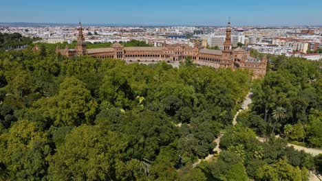 Flying-Over-The-Parque-de-Maria-Luisa-To-The-Plaza-de-España-In-Seville,-Spain