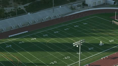 Campo-De-Fútbol-Americano-De-Escuela-Secundaria-O-Universidad---Inclinación-Aérea-Ascendente-Hacia-Abajo