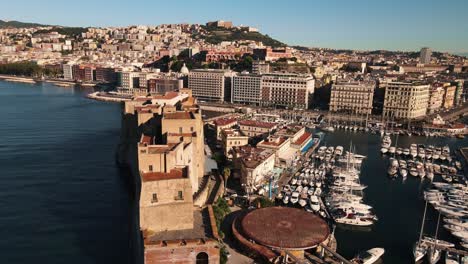 Drone-orbiting-around-a-fort-which-is-located-on-a-sea-coast-in-Italy,-Naples