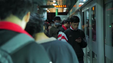 Fila-De-Hombres-Asiáticos-Adultos-Jóvenes-Esperando-Cortésmente-En-La-Plataforma-Del-Metro-De-Mano