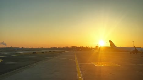 Airport-scene,-as-seen-by-the-pilots,-in-Bologna-airport,-Italy,-at-sunrise-in-a-cold-winter-day-with-an-spectacular-orange-sky