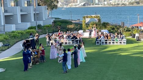 La-Novia-Hace-Su-Gran-Entrada-En-Una-Ceremonia-De-Boda-Tradicional-India-En-El-Césped-De-Un-Hotel-Frente-Al-Mar