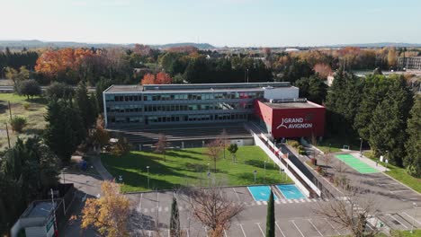 Toma-Aérea-En-órbita-De-Un-Edificio-De-Oficinas-Con-Banderas-Ondeando-Al-Viento